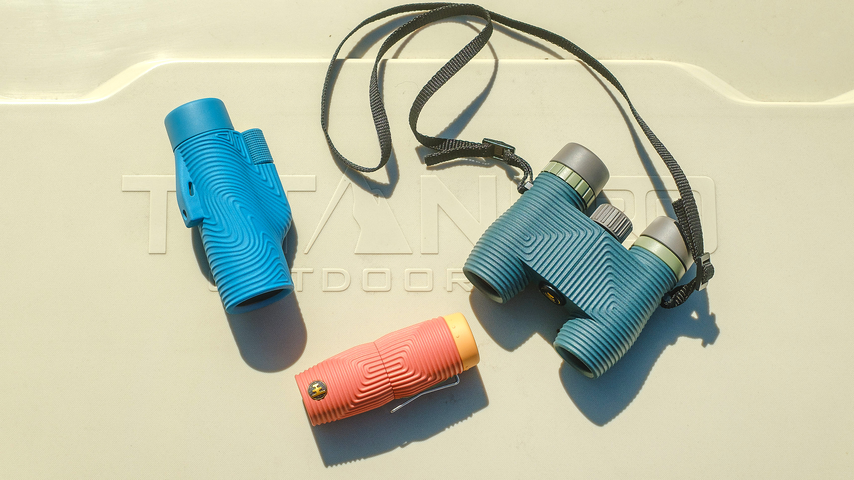 Photo of the Nocs Zoom Tube, Zero Tube and Nocs binoculars sitting on a cooler
