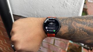 The Suunto Race 2 watch worn on a wrist displaying battery percentage 