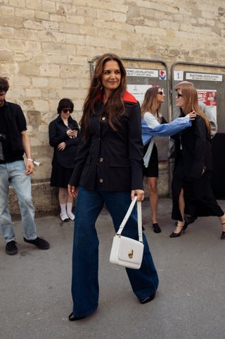 katie holmes wewarng a buttoned coat, jeans, and boots