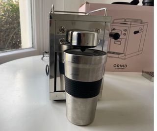 Grind One Pod Machine with a travel cup underneath