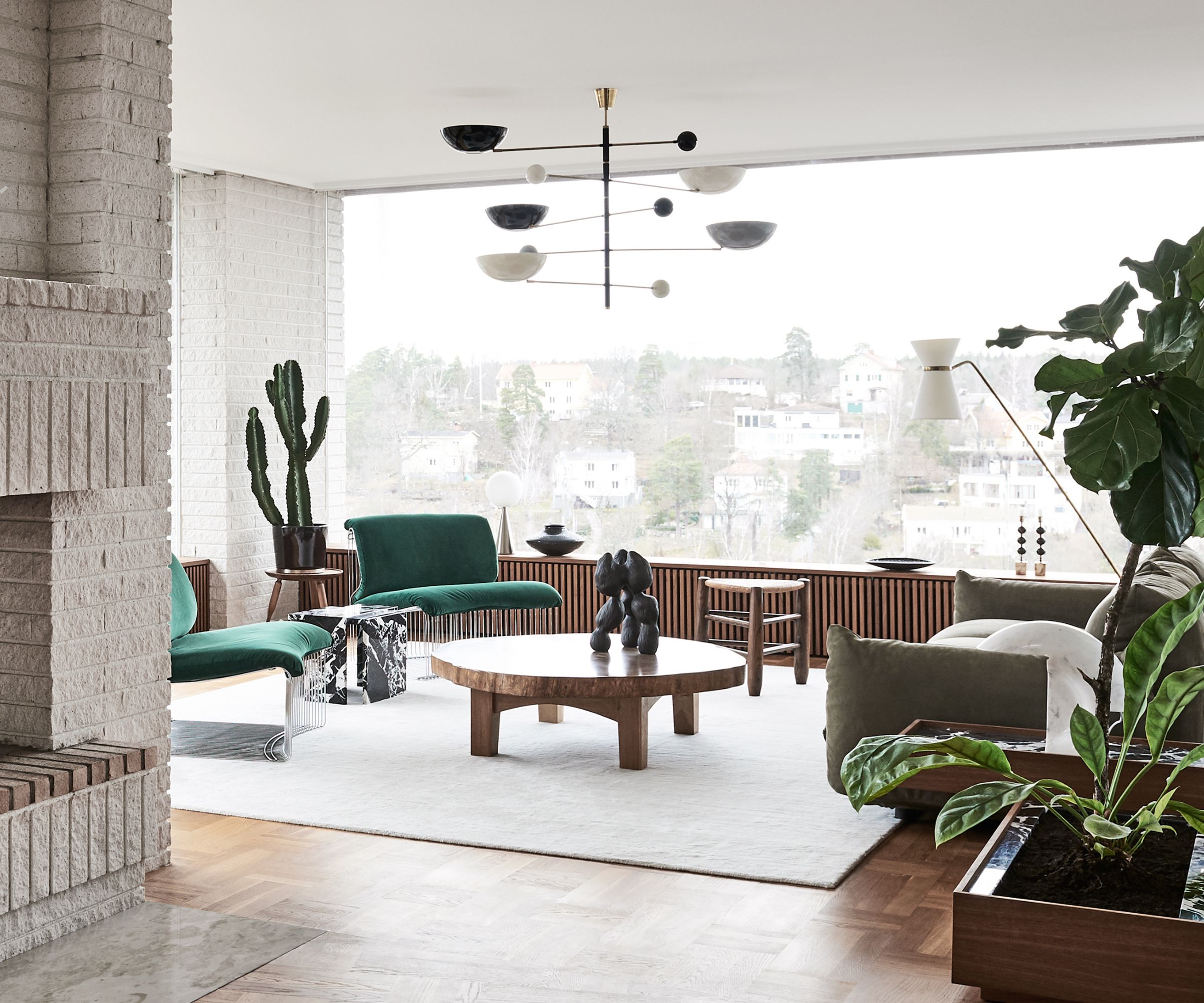 living room with brick fireplace and green chairs