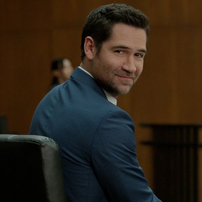 manuel garcia rulfo as mickey haller turning over his shoulder to look at the crowd in a court room in a still from the lincoln lawyer season 4