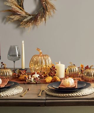 Dining table laid with halloween decorations and light-up pumpkins