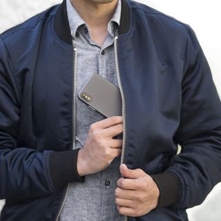 Totallee Thin iPhone XS Case on iPhone being put into jacket pocket by man