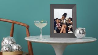 One of the best digital photo frames, showing a shot of a family gathered on the sofa and laughing together