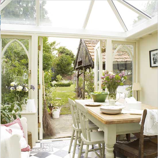 white conservatory with dining table and flower vase