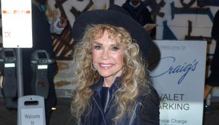 Dyan Cannon in a black leather jacket and hat.