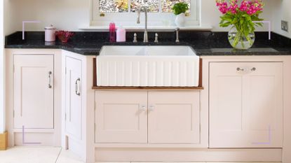 Cream kitchen with Shaker cabinets and storage under a Butler sink to show how to organise under kitchen sink
