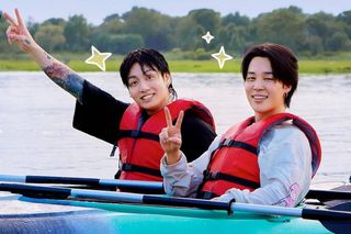 Jimin and Jungkook in their Disney+ travel series, Are You Sure?!. The pair are sat in kyaks throwing up the peace sign