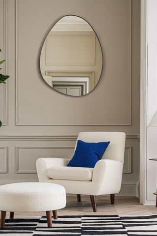 A living room with wall panelling and a white arm chair