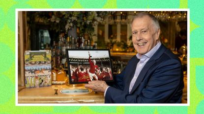 Sir Geoff Hurst holding a photo from the World Cup in 1966 whilst sat in The Ivy