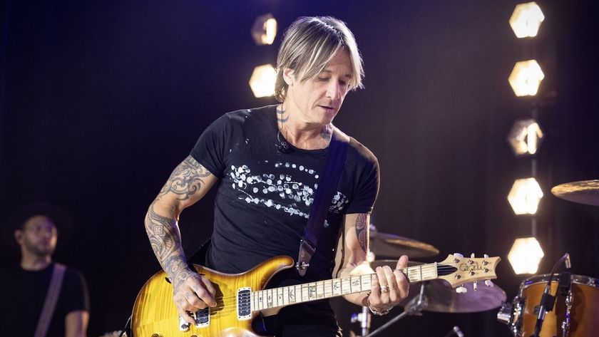 Keith Urban playing the guitar in the series premiere of The Road on CBS