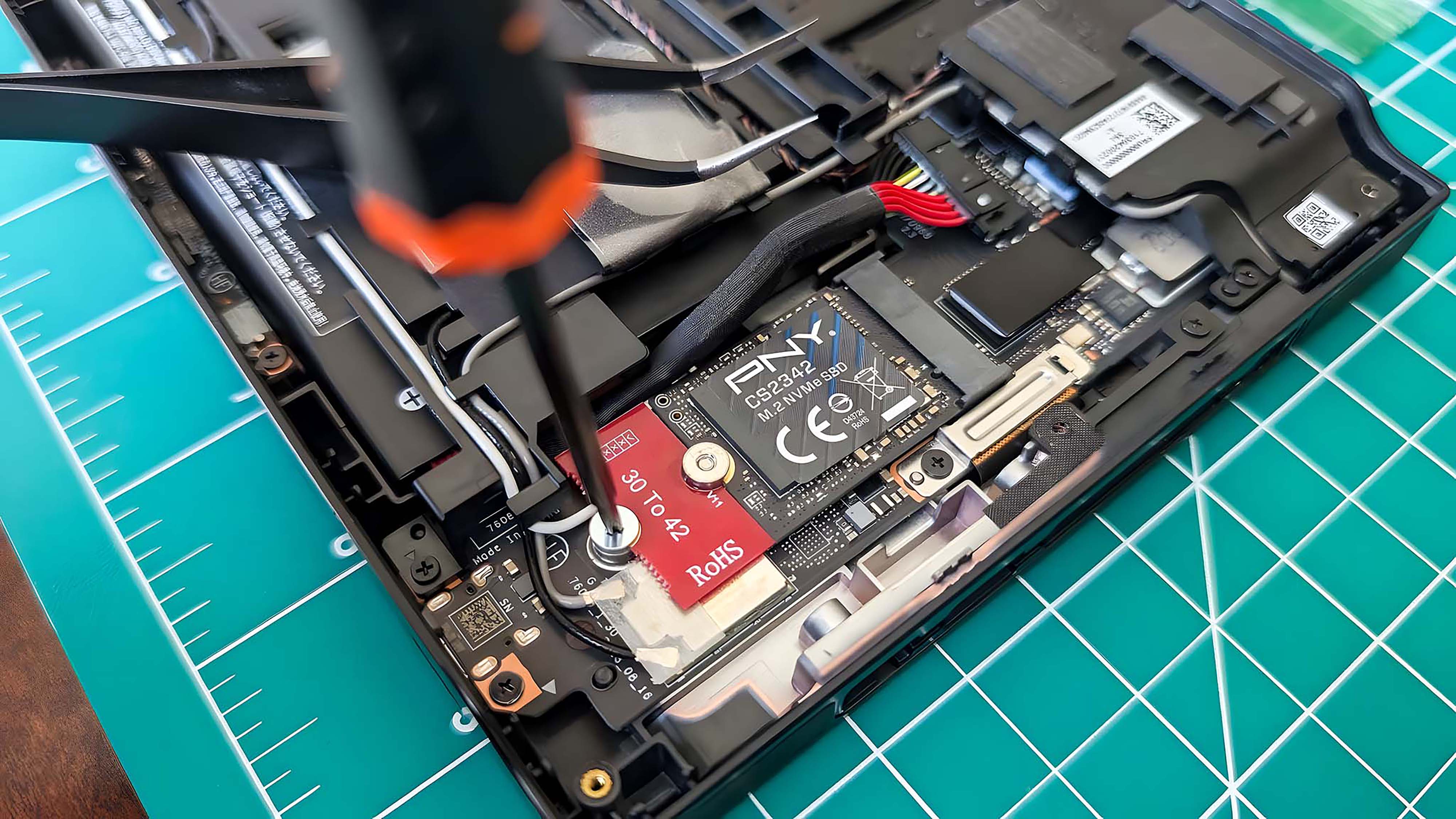 A screwdriver securing the new Lenovo Legion Go SSD in place.