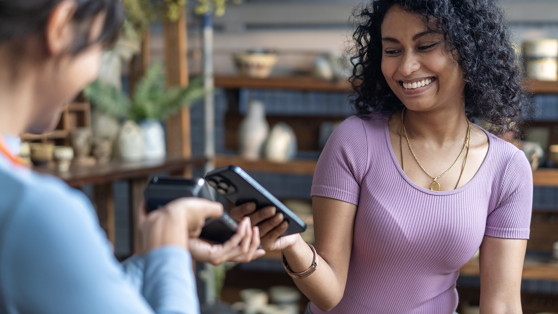 Woman paying using iPhone in shop