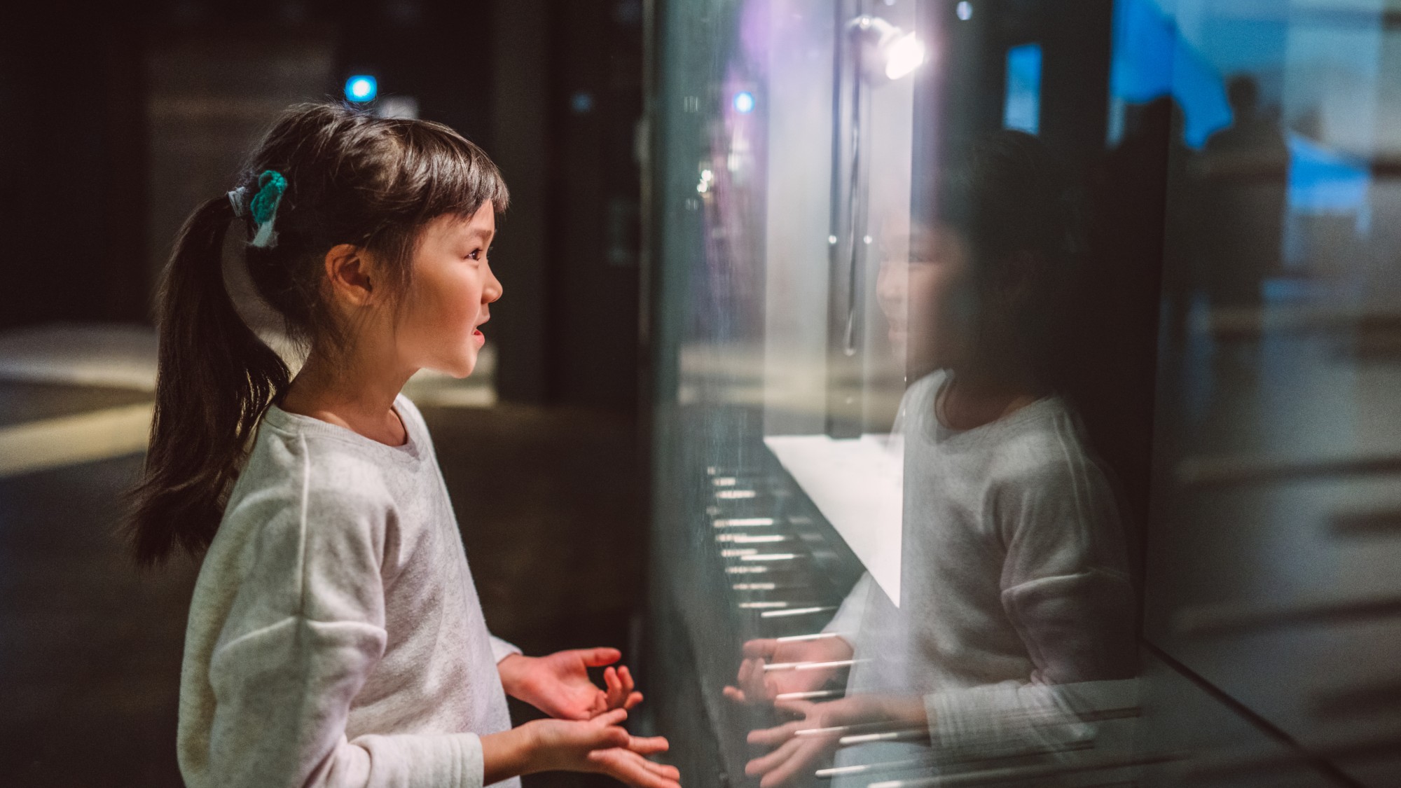 Young girl interacting with a museum exhibit