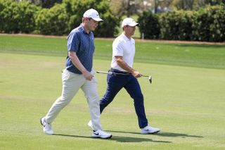 Robert MacIntyre and Rory McIlroy walk down the fairway