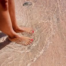 french pedicure - Woman's pedicure in the water and sand at the beach - gettyimages 1353071606