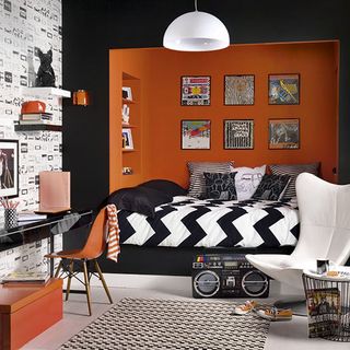 bedroom with orange and black wall and black and white bedding set