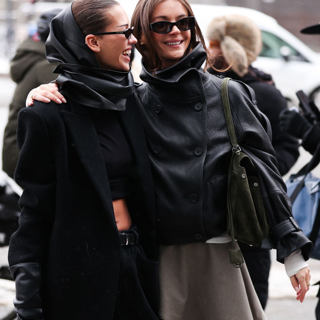 two copenhagen fashion week attendees smiling wearing sunglasses