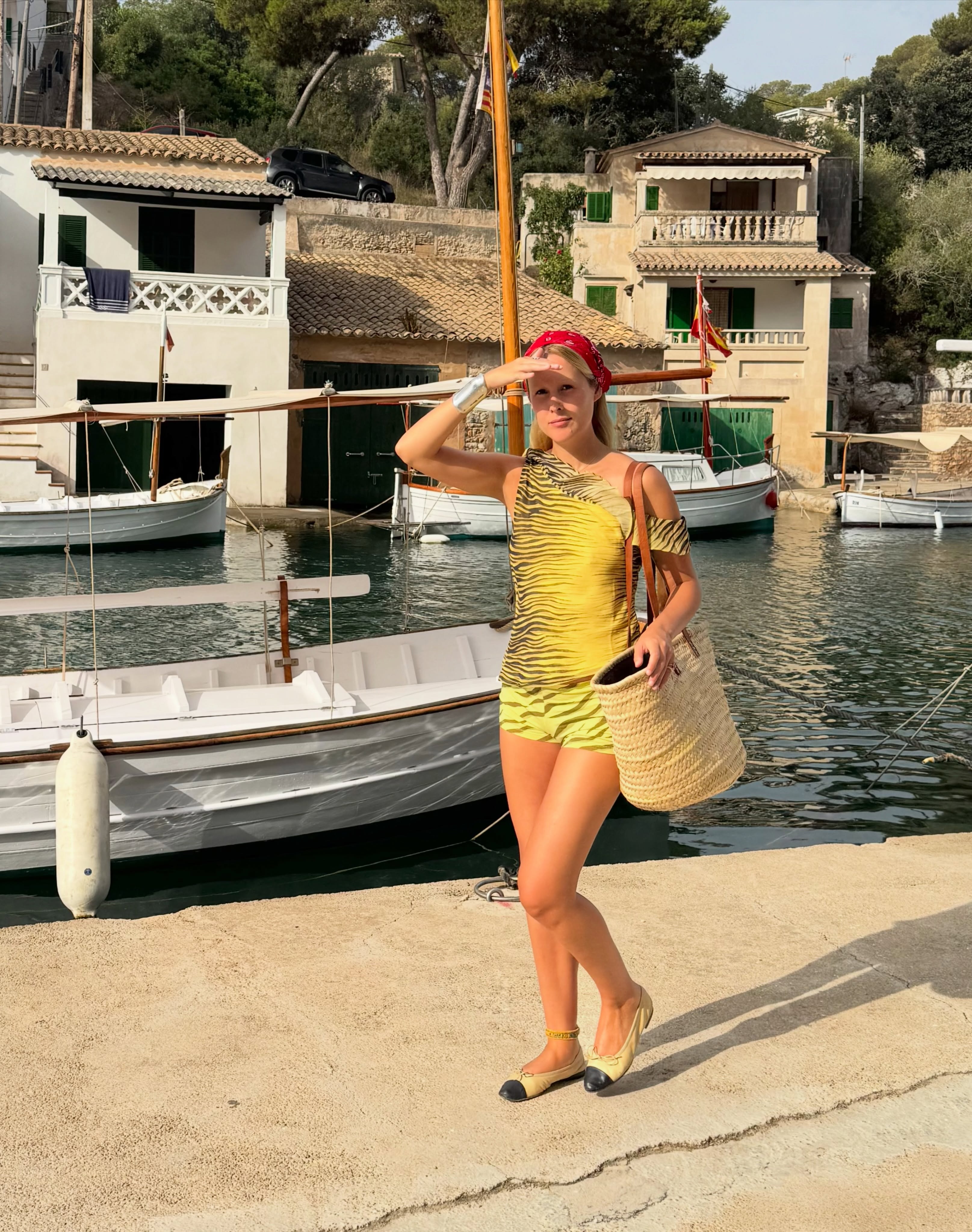 Spanish woman wearing oversize raffia bag, a summer trend.