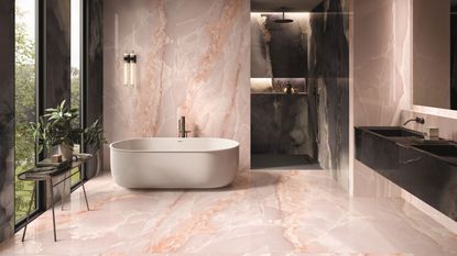 Tile trends 2023. Luxurious bathroom with large format pink onyx porcelain tiles, white bath, black sink, console table with plants, built in shower with dark tiles.