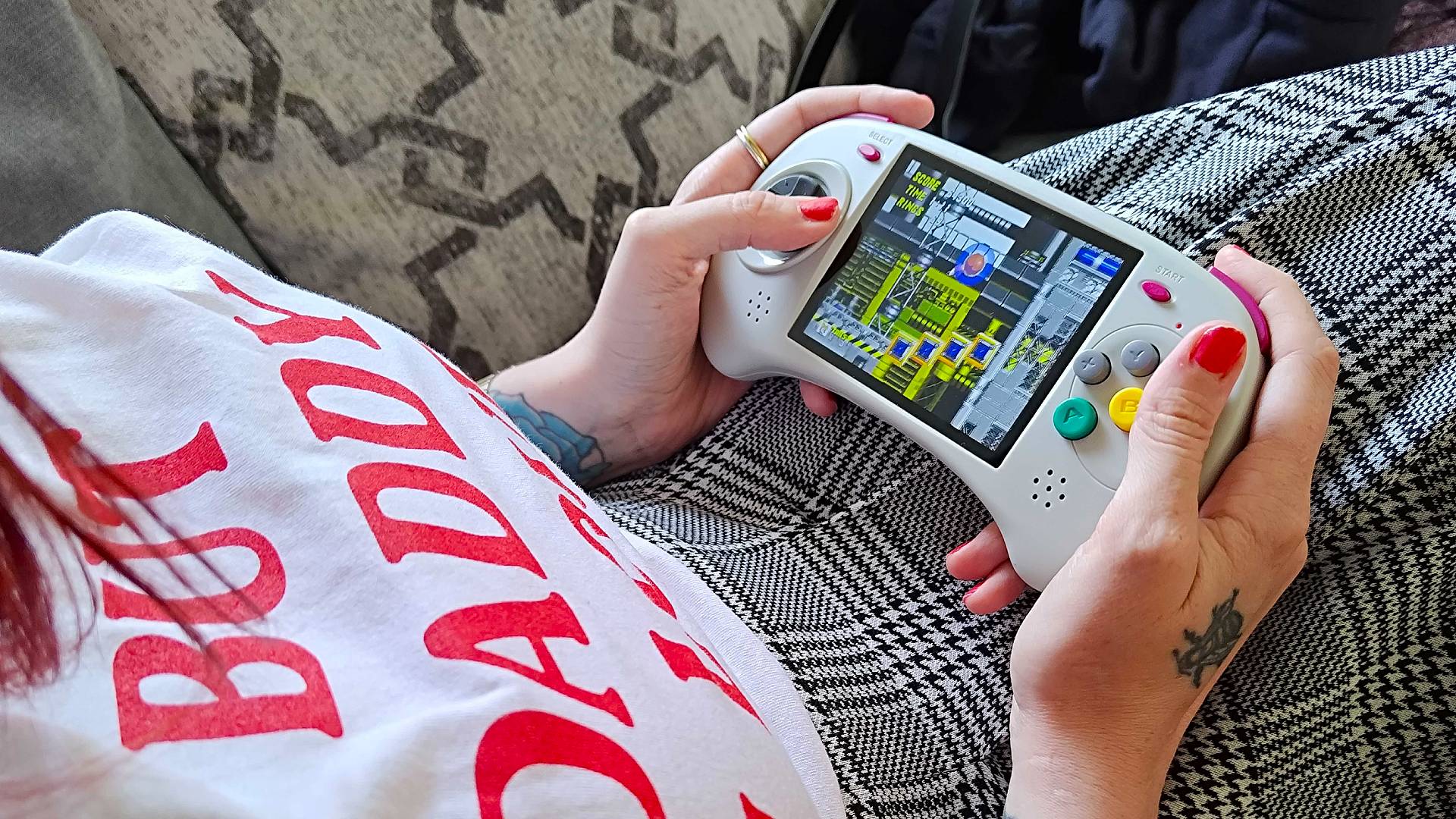 Hands holding Anbernic RG ARC-D with Sonic the Hedgehog 2 gameplay on screen.
