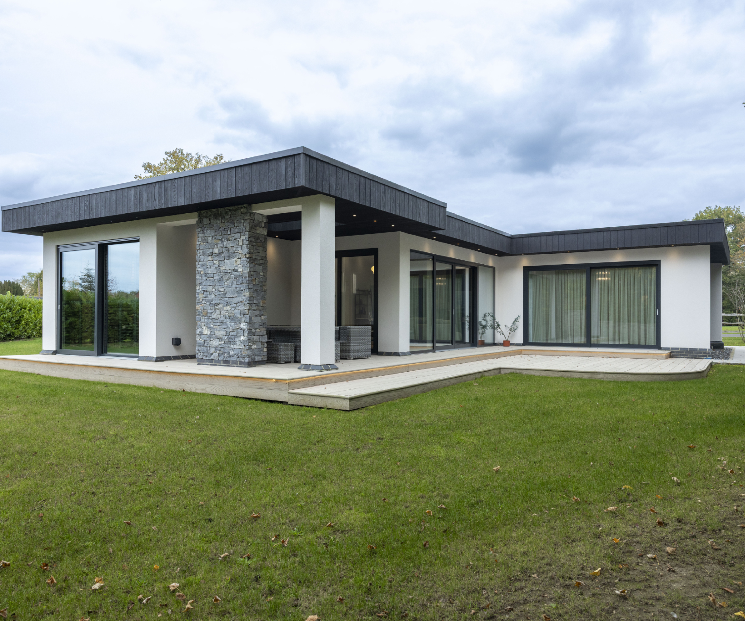 modern timber frame home with flat roof, render and stone finish and bi-fold doors