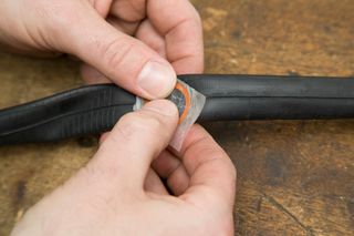 Image shows a rider using a patch to repair a puncture.