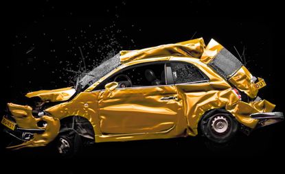 An image of a smashed up gold car on a black background.