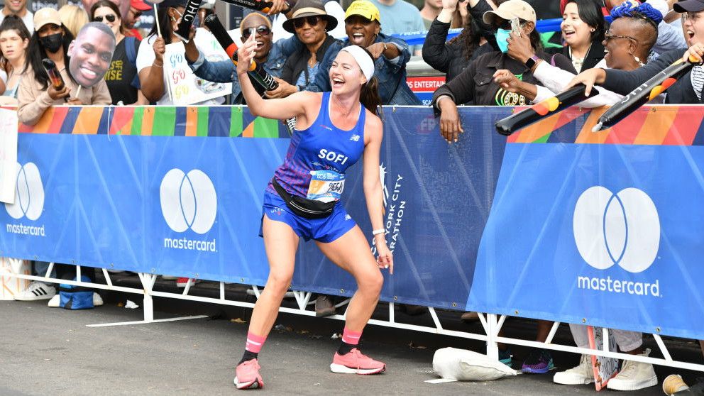 Runner Sofia Maria Jimenez stops and takes a picture with fans during the 2022 TCS New York City Marathon