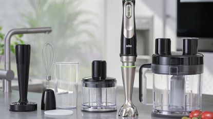 A Braun Multiquick 9 hand blender with all of its attachments spread out on a grey kitchen counter
