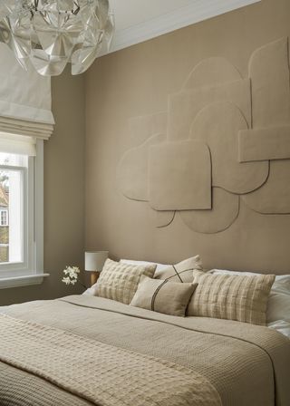 beige bedroom with large headboard covering the whole wall