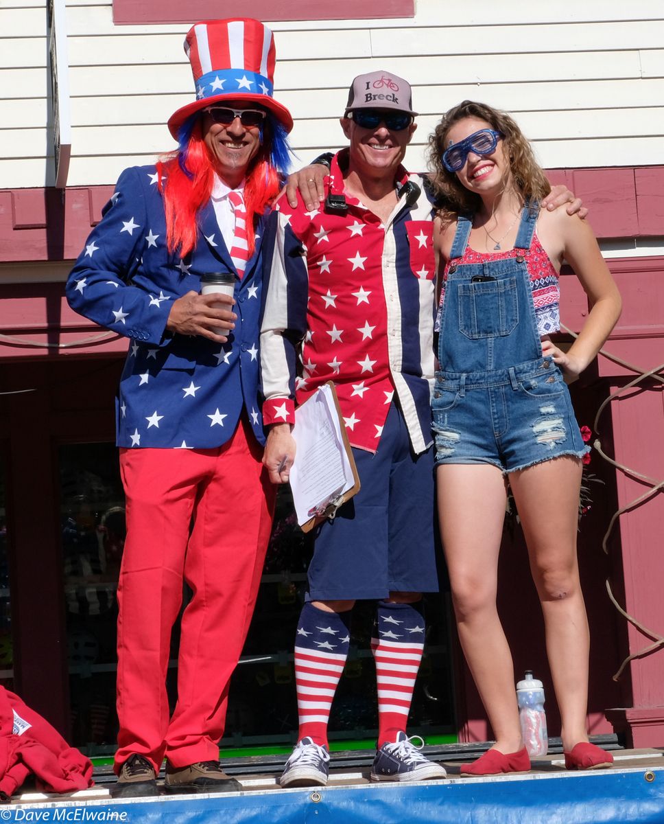 Announcer Larry Grossman, race organizer Jeff Westcott, and an unidentified young woman on the stage before the race