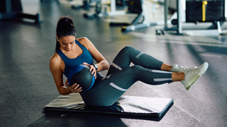 Woman doing Russian twists in gym