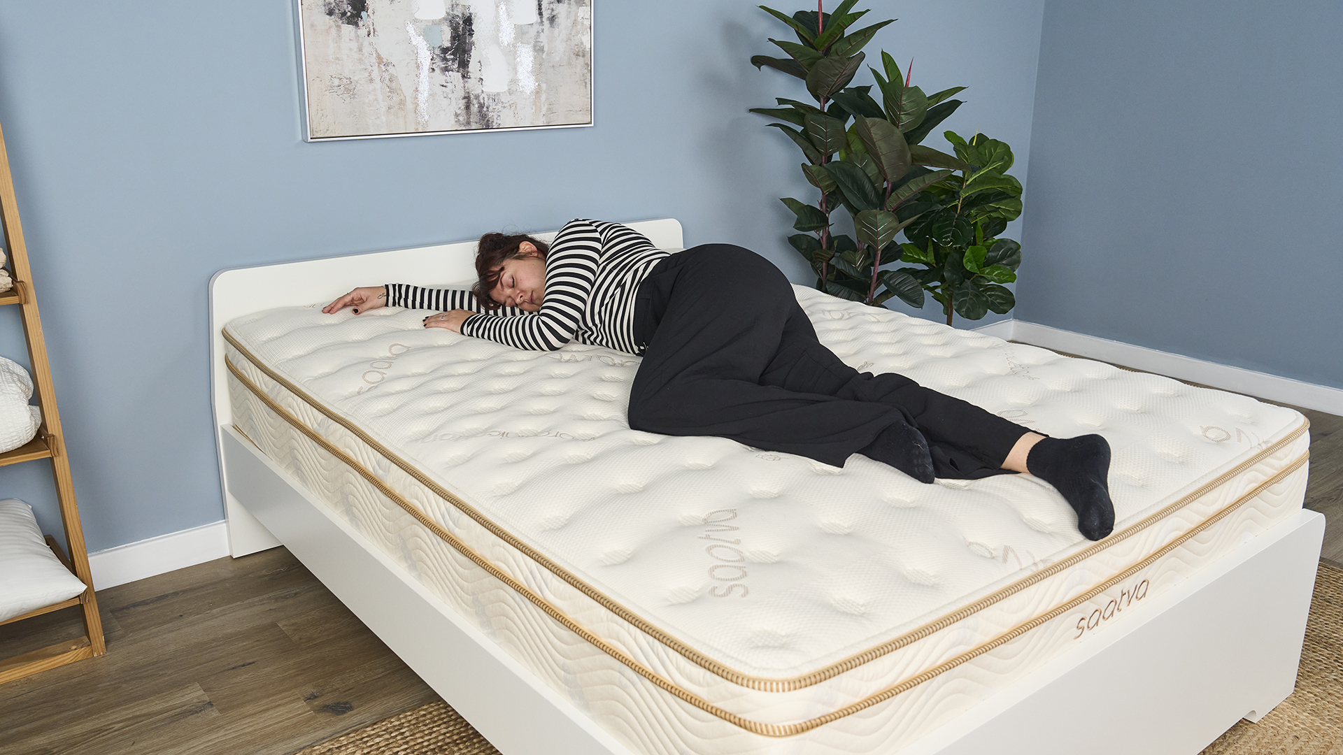 One of our mattress testers sleeps on her right side in the center of the Saatva Classic mattress