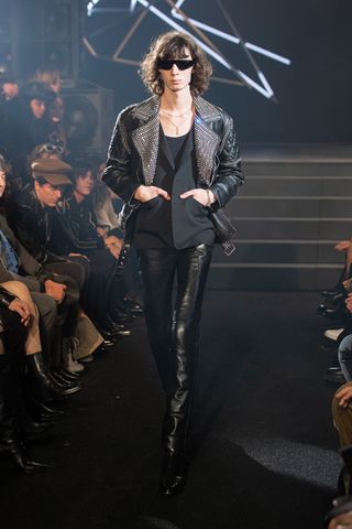 Man on Celine runway in studded biker jacket and leather trousers