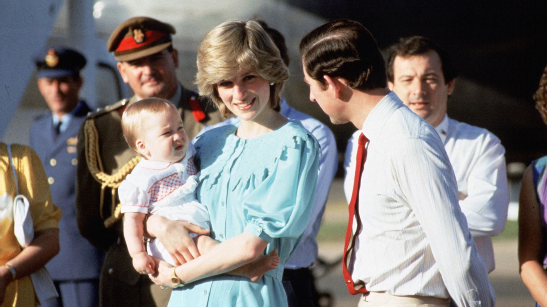 Princess Diana holds a baby Prince William in Australia, with Prince Charles to her side