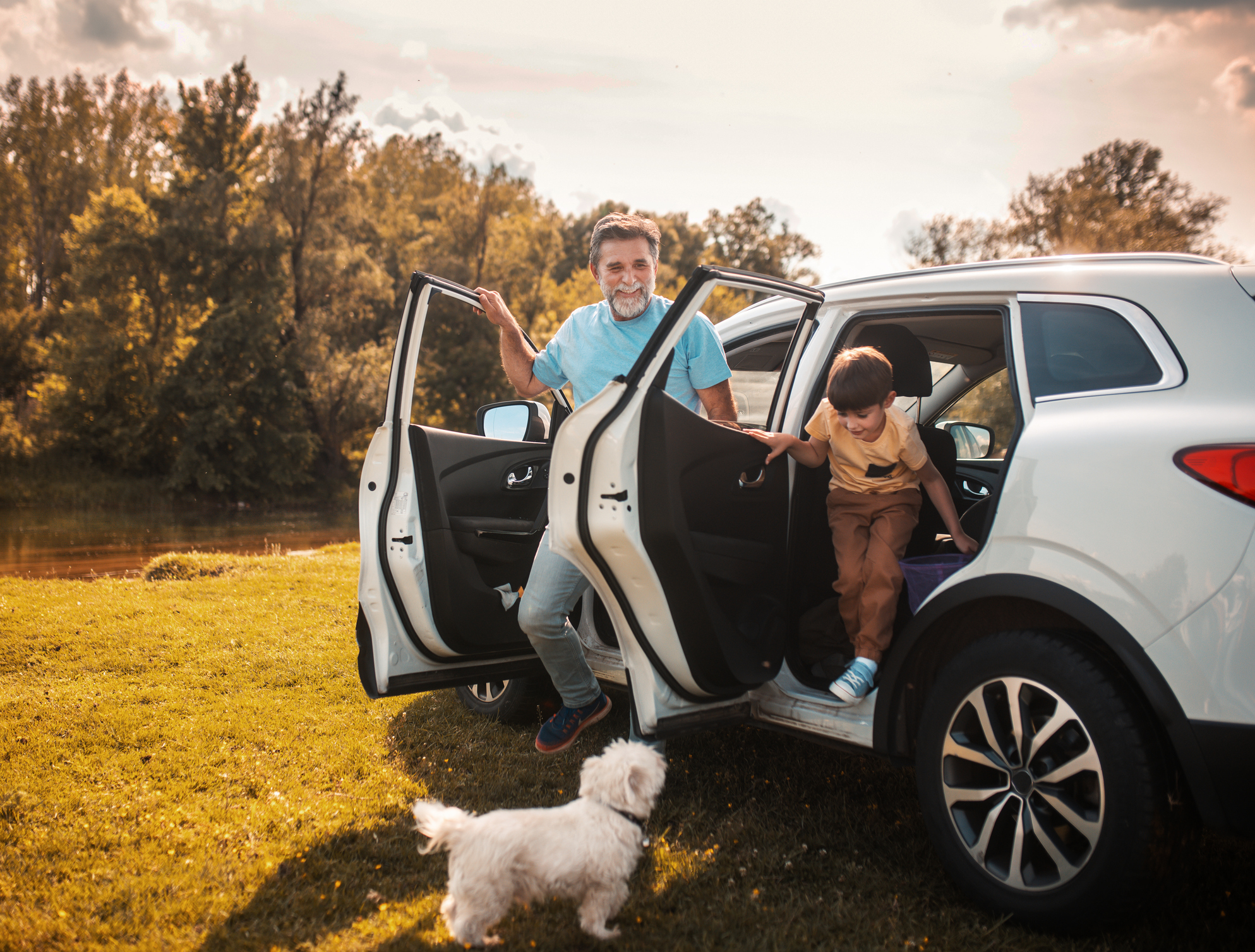 A father and son get out of a car in a wilderness area.