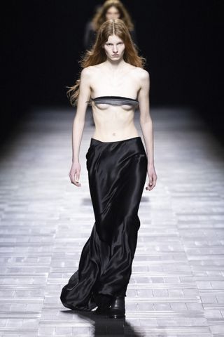 Woman in Ann Demeulemeester feather bra top and black skirt