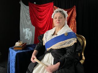 An actor portrays Queen Victoria in her later years.