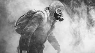 Black and white still from The Eternaut of a man wearing a gas mask, backpack, and snow clothes trudging through a cloud of smoke.