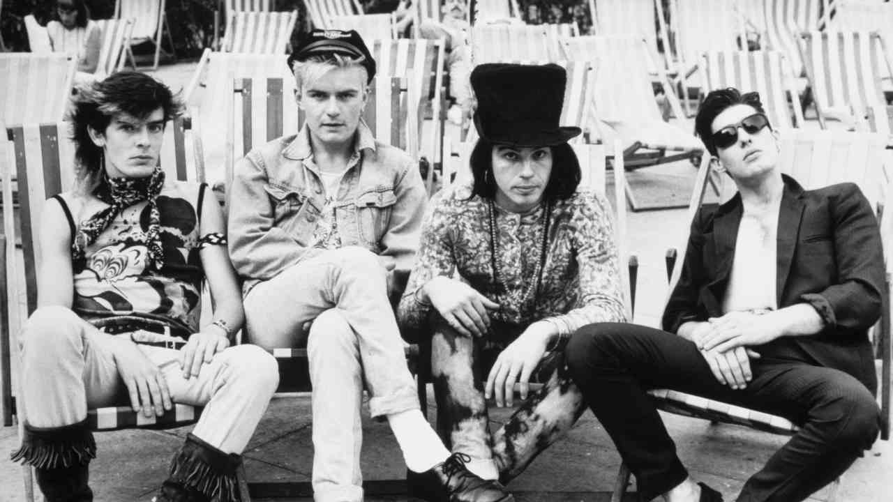 The Cult posing for a photograph on deckchairs in 1984