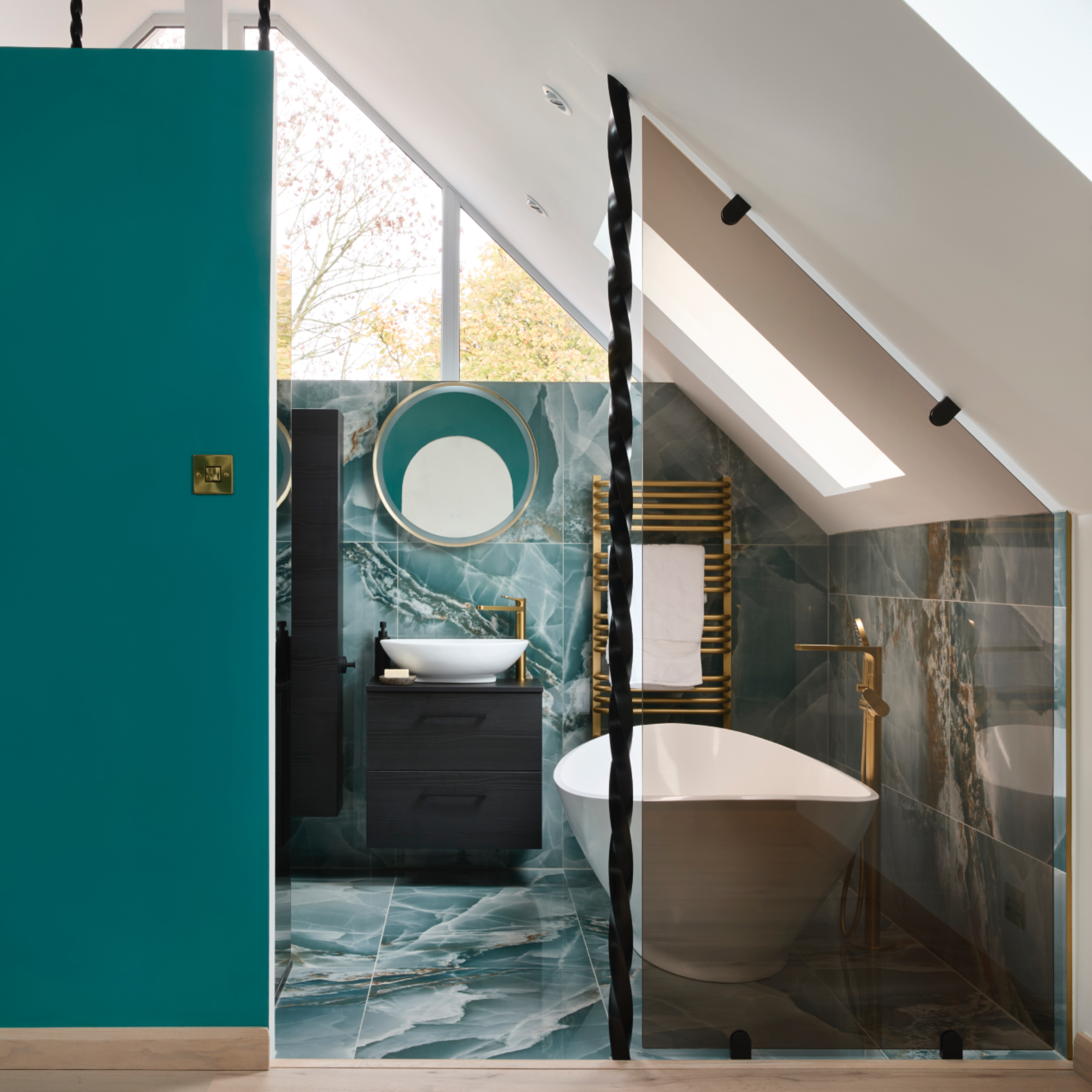 teal bathroom with modern bath, teal marble tiles, brassware, mirror