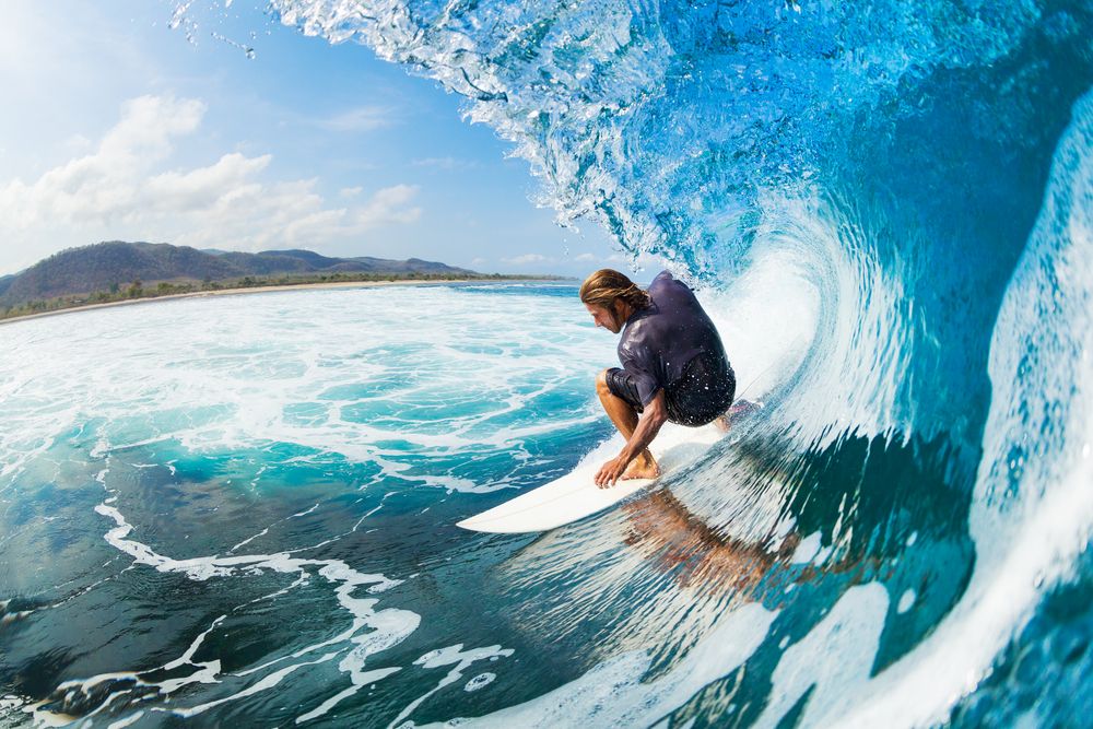 Surfer on Blue Ocean Wave in the Tube Getting Barreled 