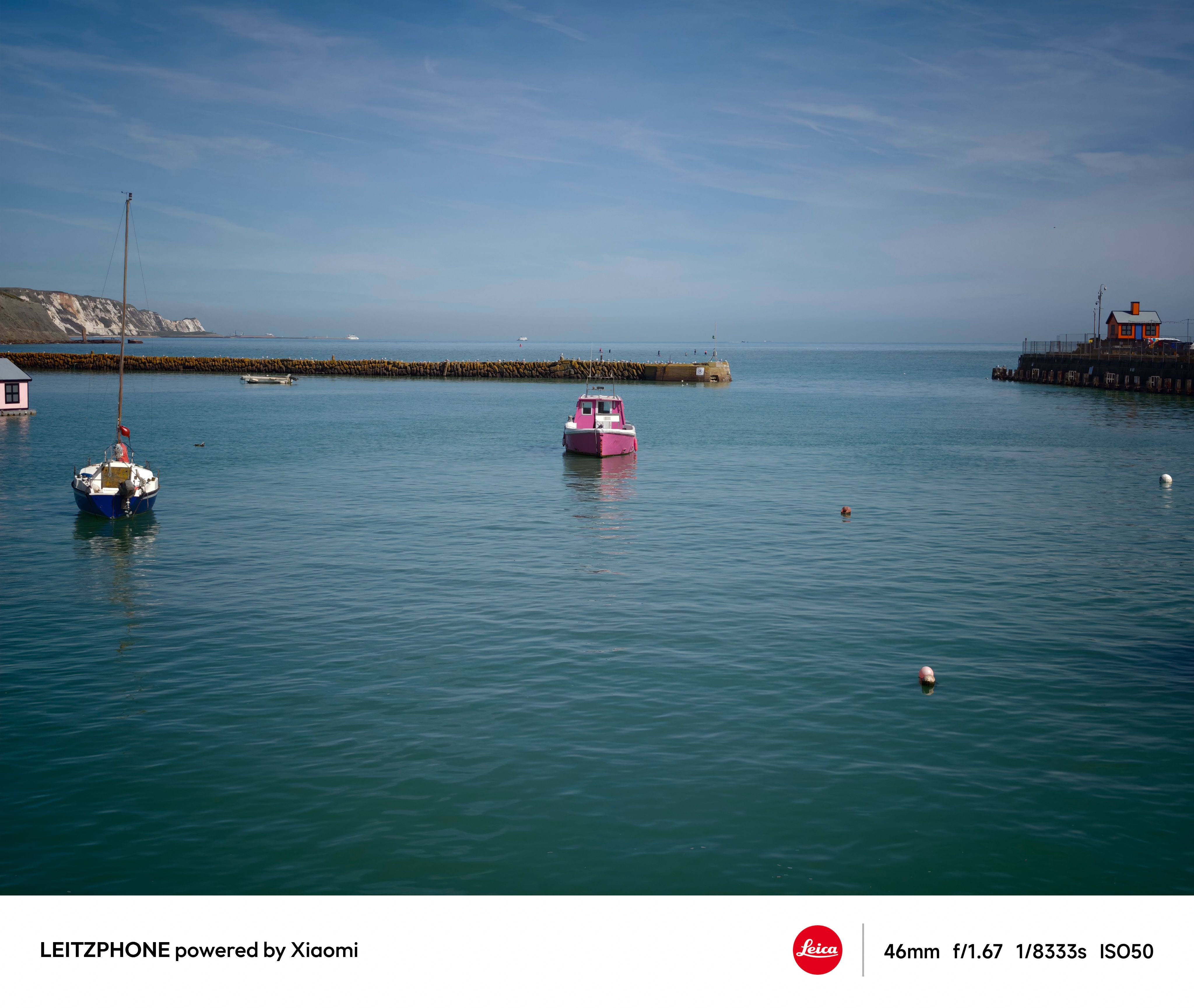 Pink boat floating in a calm harbor