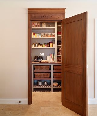 walk in pantry with wooden door and the word pantry carved into wooden frame above the door