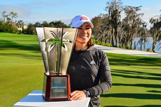 Danielle Kang poses next to a trophy