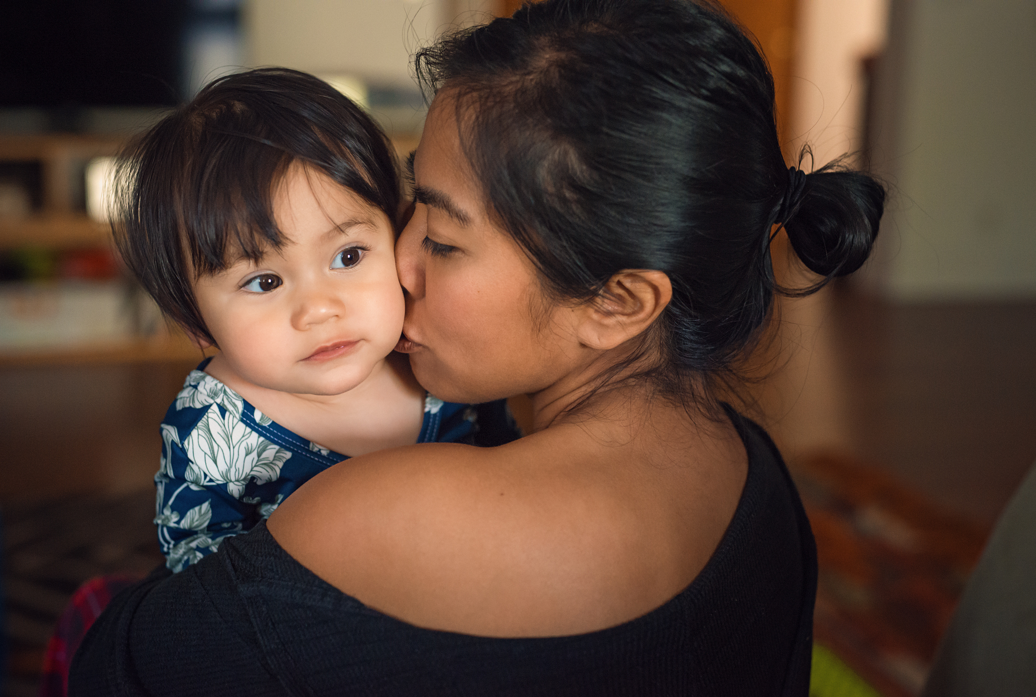 Woman holds baby girl over her shoulder