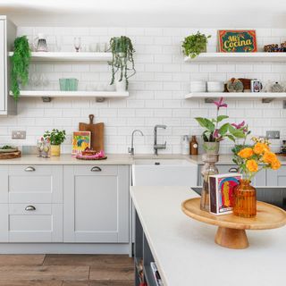 kitchen with white cabinets, island unit, open shelving and various kitchen items on display