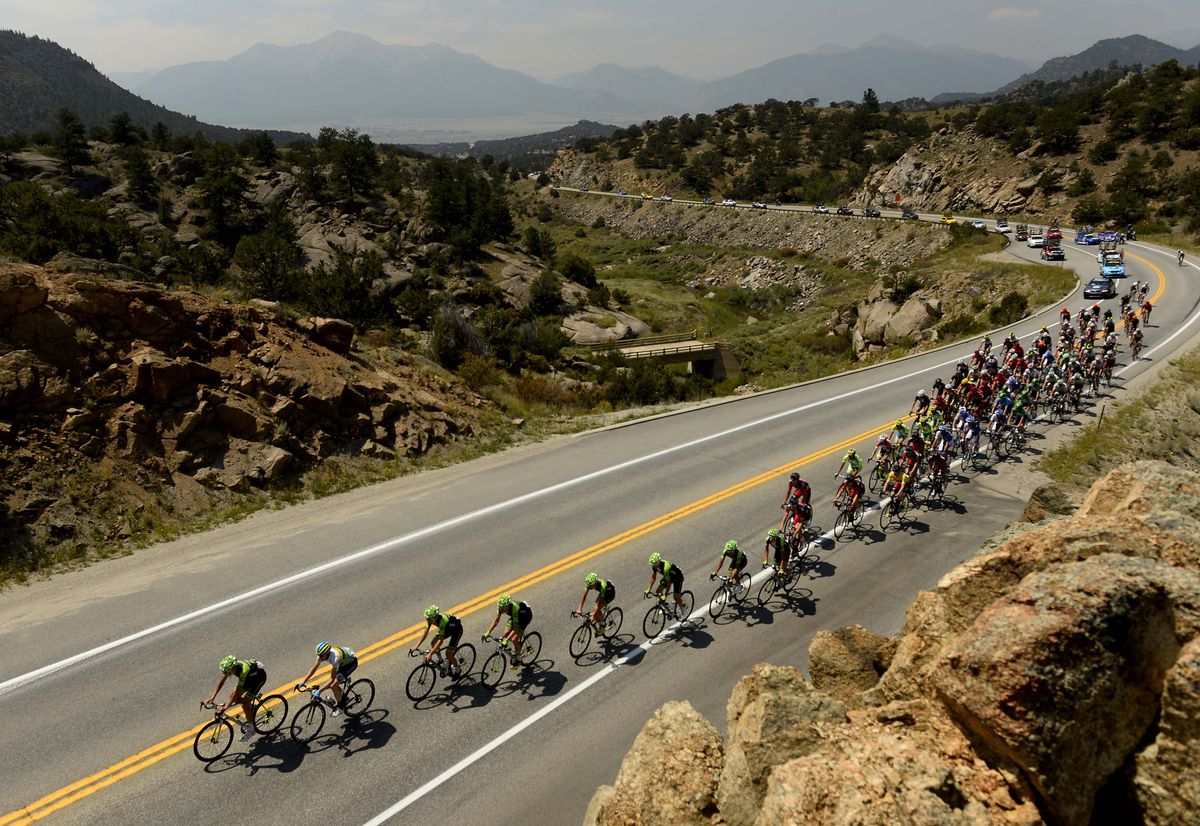 The peloton is lined out on a climb